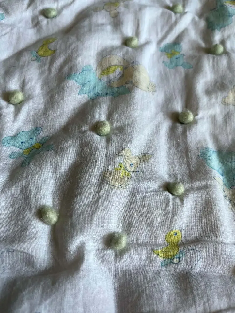 Vintage Style Baby Nursery Crib Quilt with Pom-Pom Accents and Animal Print